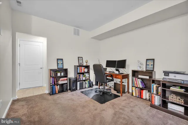 a view of a livingroom with workspace and a flat screen tv