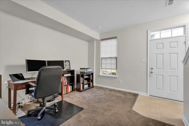 a view of a workspace with furniture and a window