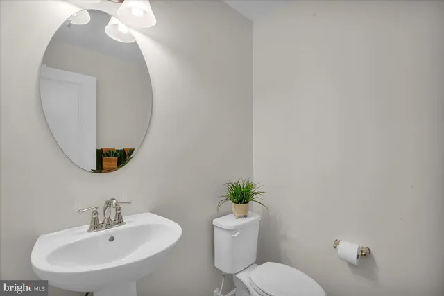 a bathroom with a toilet a sink and a mirror