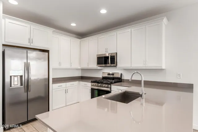 an empty room with wooden floor ceiling fan and windows