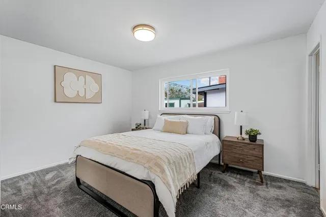 a bedroom with a bed and a painting on the wall