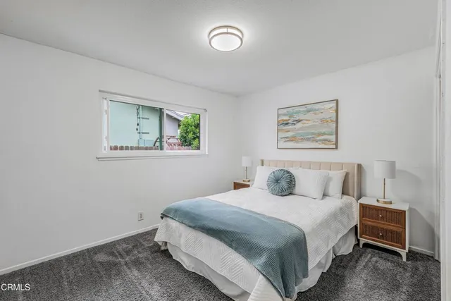 a bedroom with a bed and a painting on the wall