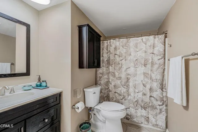 a bathroom with a granite countertop sink toilet and mirror