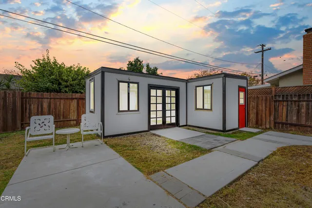 a backyard of a house with barbeque oven table and chairs