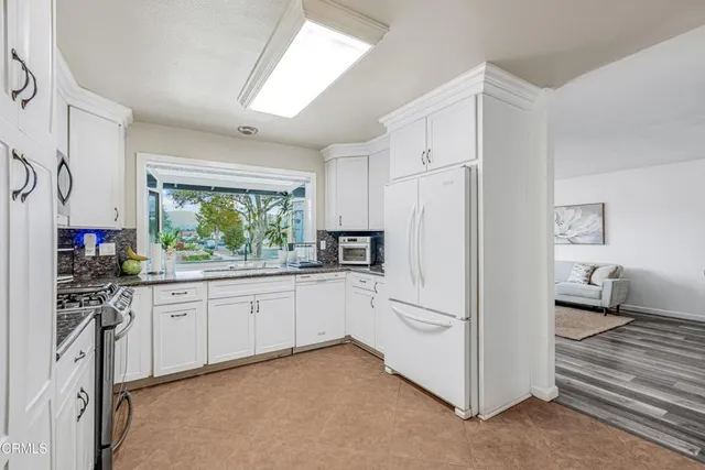 a kitchen with white cabinets and white appliances