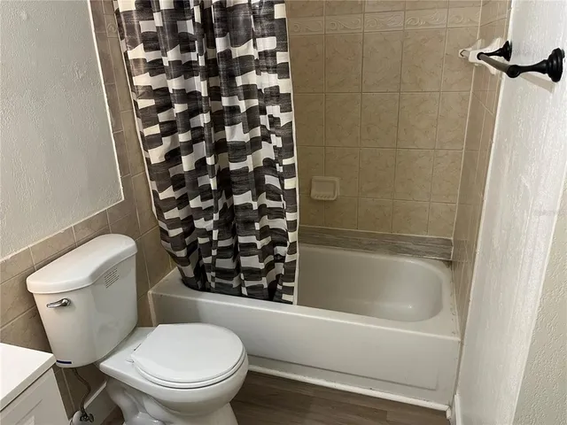 a white toilet sitting next to a bathtub
