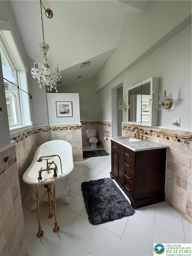 940 Jacktown Road Bangor, PA 18013 - Photo 22 of 33 Luxurious bathroom with a classic clawfoot tub, elegant chandelier, and spacious vanity.