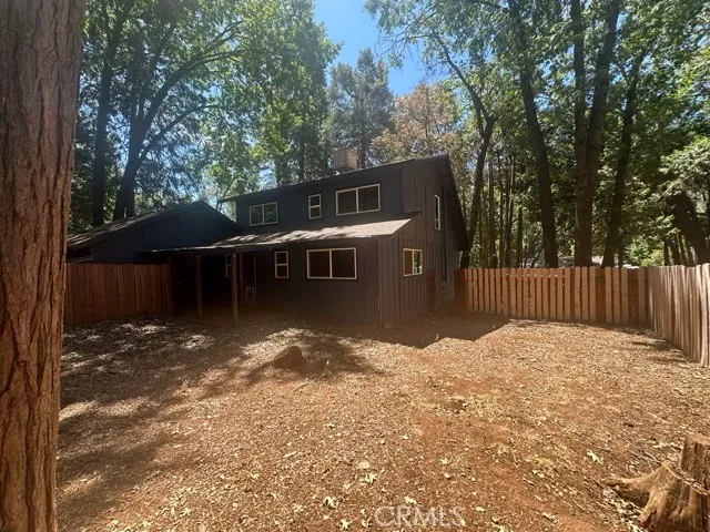 a backyard of a house with table and chairs under an umbrella