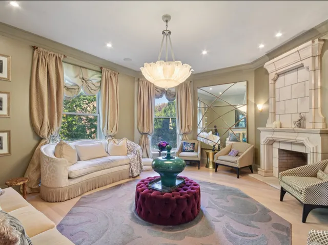 a living room with furniture a fireplace and a chandelier