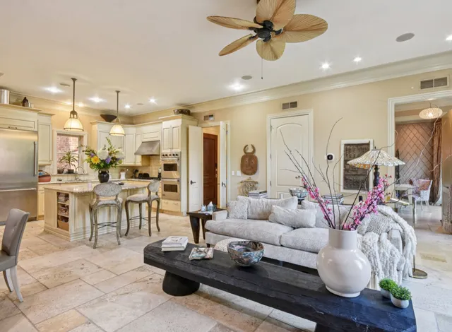 a living room with furniture a large window and a chandelier
