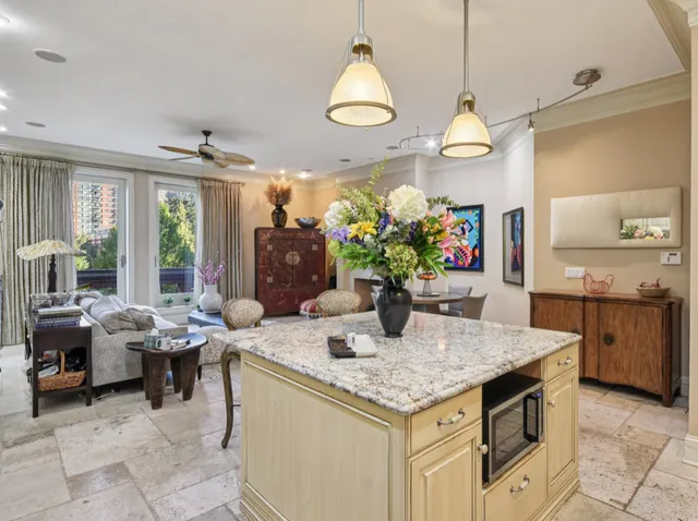 a living room with furniture kitchen view and a chandelier