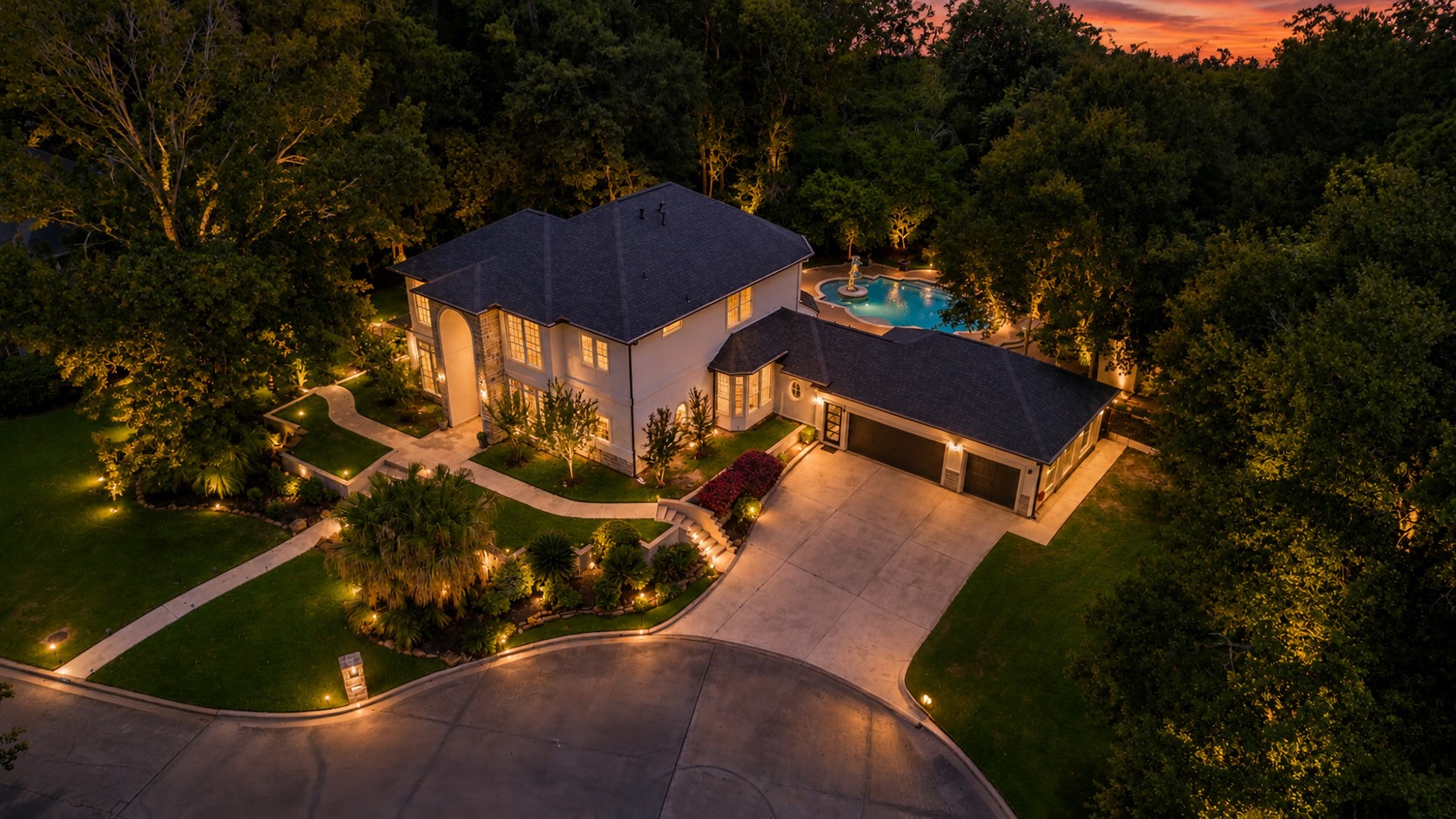1810 Woerner Road Houston, TX 77090 - Photo 2 of 39 This stunning two-story home features elegant exterior lighting, a spacious driveway, and a beautifully landscaped yard. It boasts a large pool surrounded by trees, providing a serene and private backyard oasis.