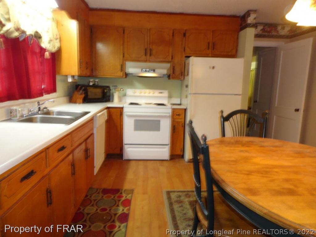 5048 Cameron Road Hope Mills, NC 28348 - Photo 6 of 15 a kitchen with a sink a stove and a refrigerator