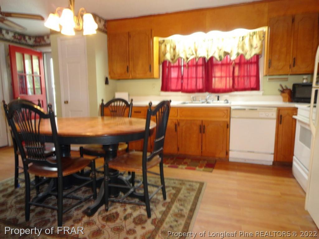 5048 Cameron Road Hope Mills, NC 28348 - Photo 7 of 15 a kitchen with a dining table chairs and a refrigerator
