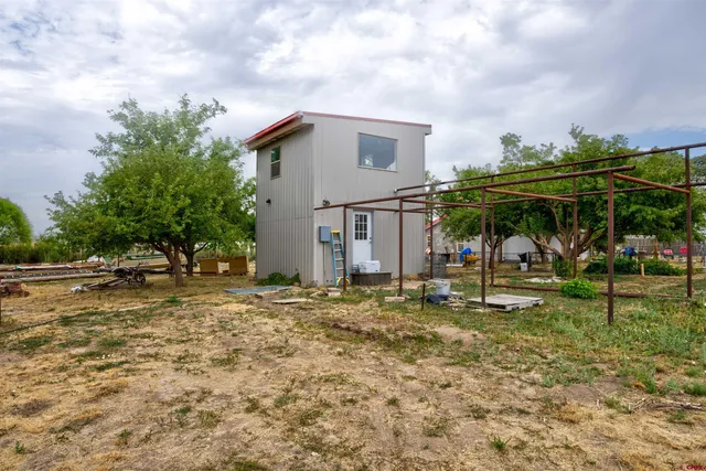 a front view of a house with garden and trees