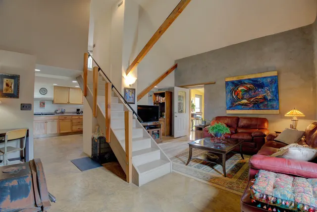 a living room with stainless steel appliances kitchen island granite countertop furniture and a wooden floor