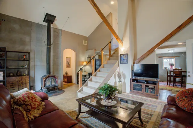 a living room with stainless steel appliances furniture and a kitchen view
