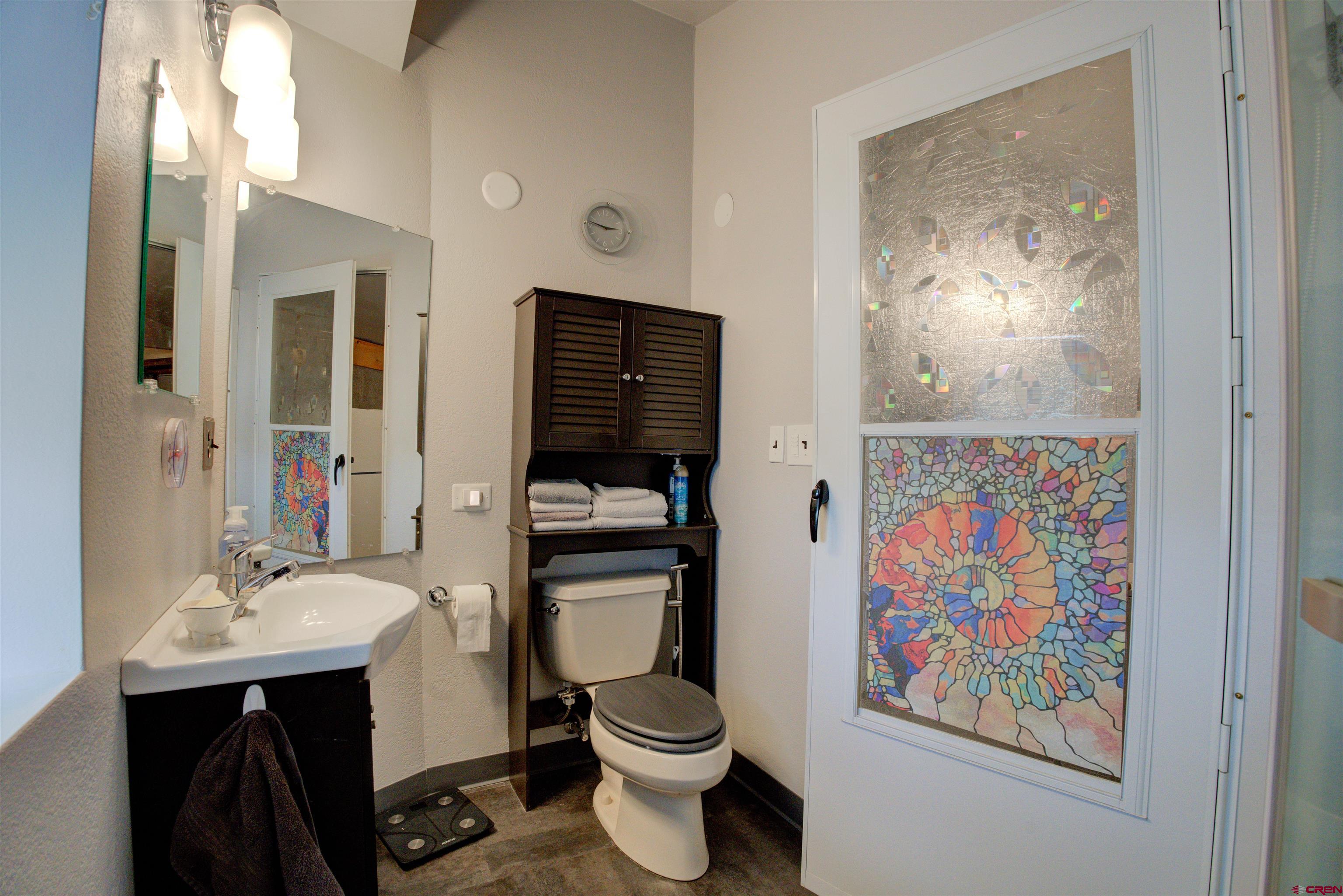 6597 Road 23 Cortez, CO 81321 - Photo 31 of 38 a bathroom with a sink a toilet and a mirror