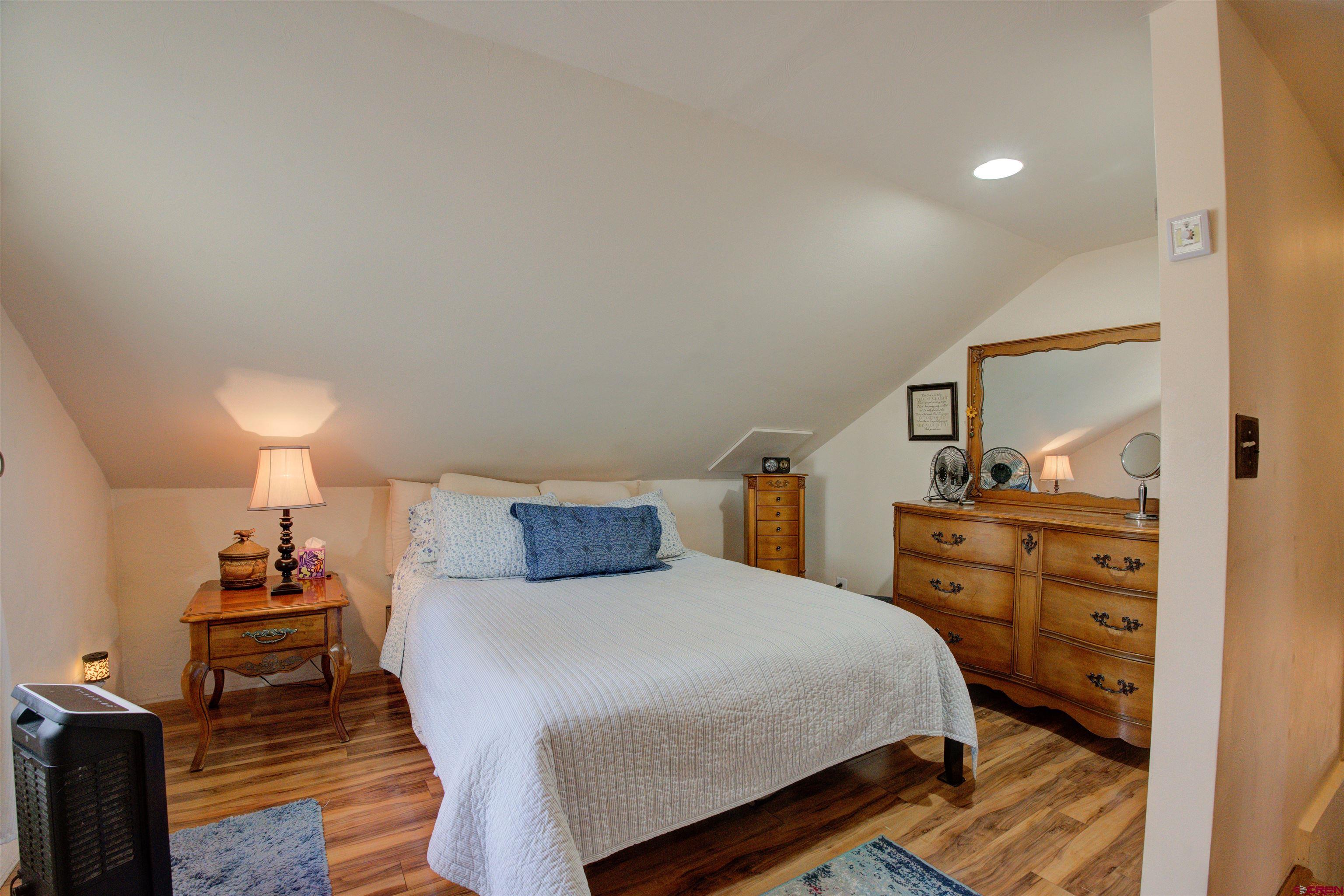 6597 Road 23 Cortez, CO 81321 - Photo 33 of 38 a bedroom with a bed and wooden floor