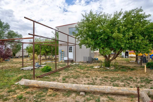 a view of a yard with table and chairs and potted plants