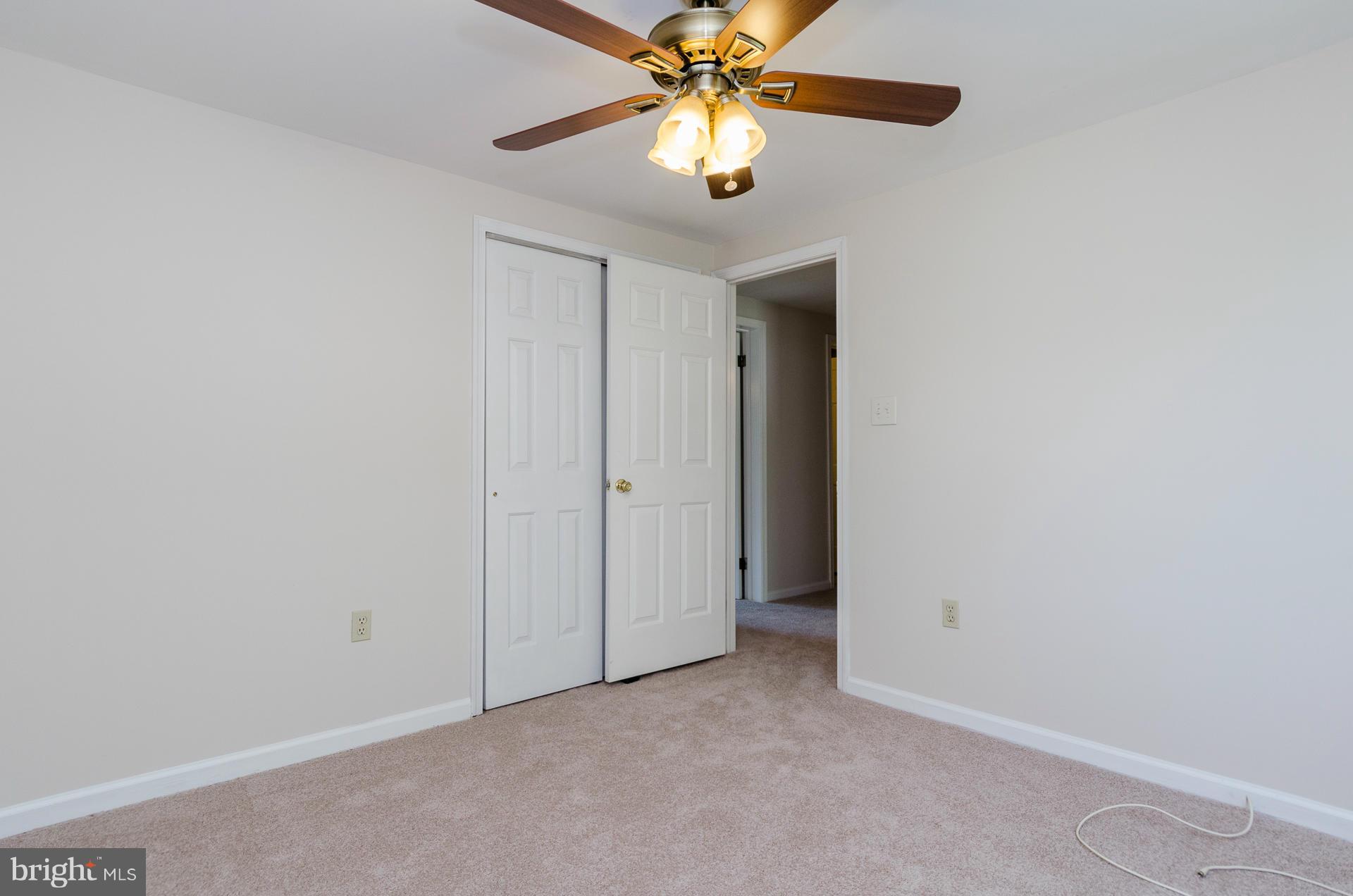3123 Ripple Road Baltimore, MD 21244 - Photo 16 of 29 an empty room with a chandelier fan and a ceiling fan