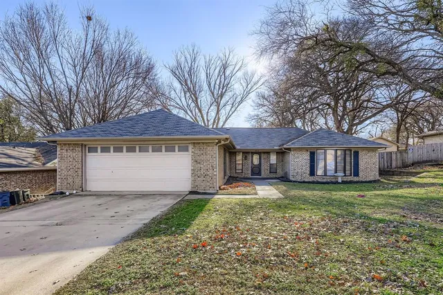 a view of a house with a yard and large tree