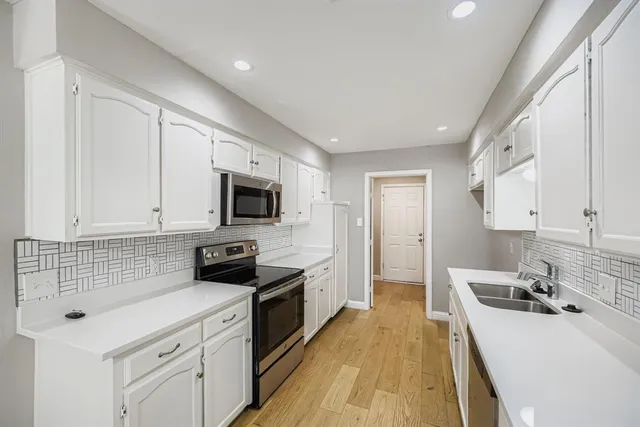a kitchen with a sink a stove and cabinets