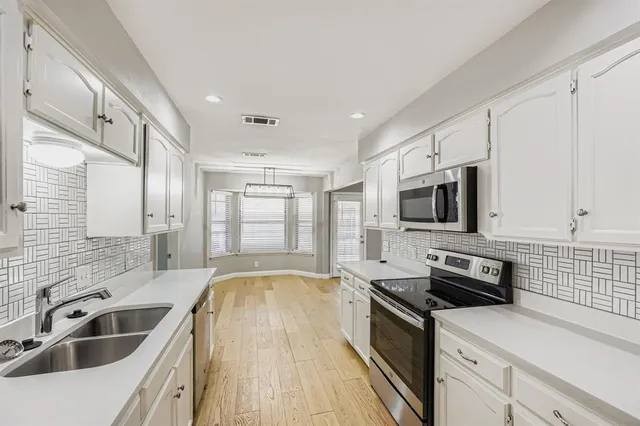 a kitchen with a sink stove top oven and refrigerator