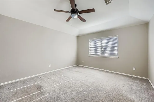an empty room with a window and a fan