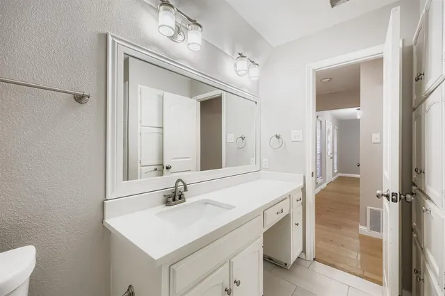 a bathroom with a sink vanity granite and a mirror