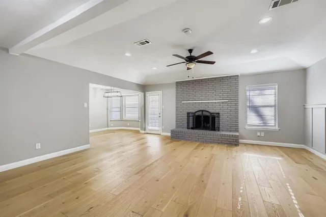 a view of an empty room with a fireplace and a window