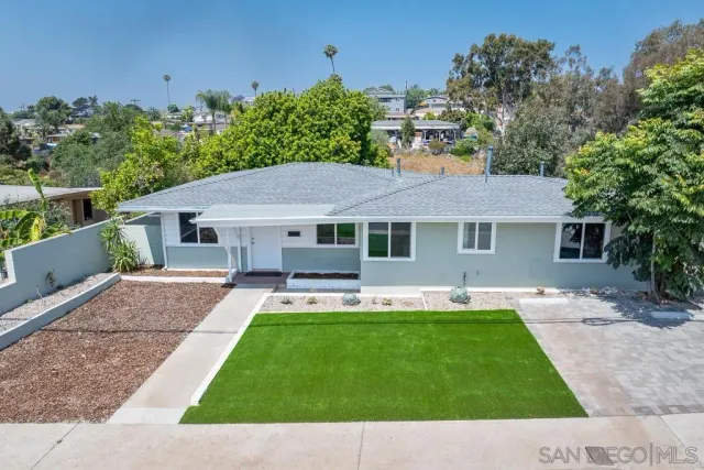 a view of a house with a yard and sitting area