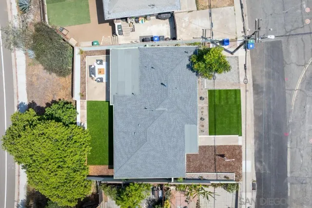 an aerial view of residential houses with outdoor space and trees