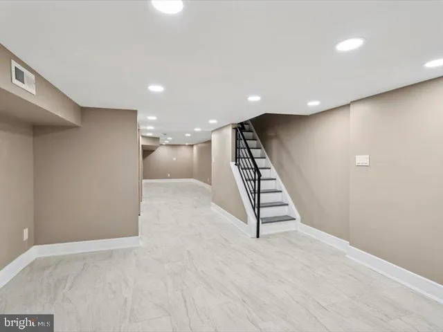 an empty room with wooden floor and staircase