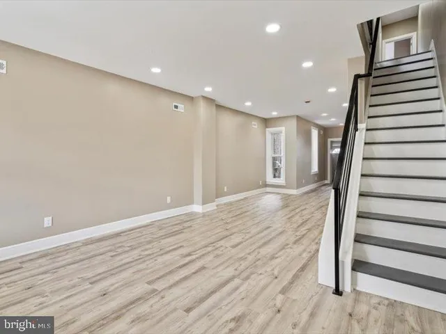 a view of a hallway with wooden floor and staircase