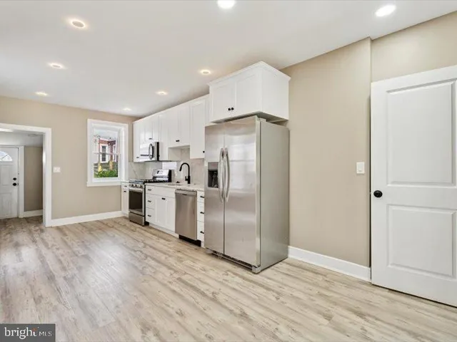 a kitchen with stainless steel appliances a refrigerator and wooden floor