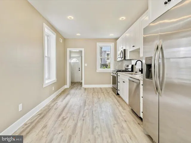 a kitchen with stainless steel appliances a refrigerator sink and cabinets