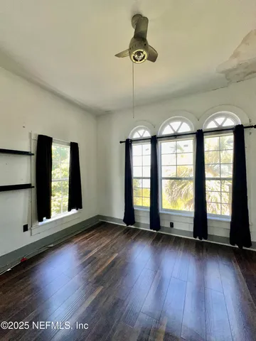 a bedroom with two beds and a large mirror next to a window