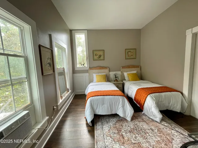 a bedroom with two beds and a large window