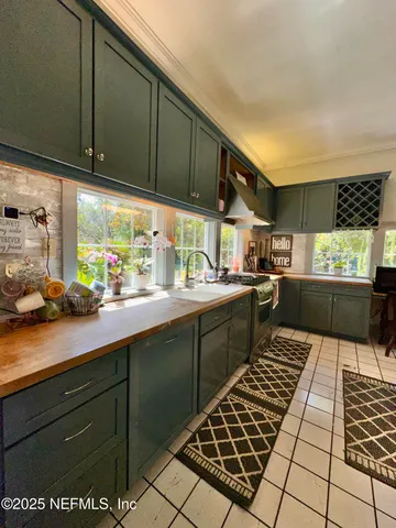 a kitchen with stainless steel appliances wooden cabinets a stove a sink and a microwave