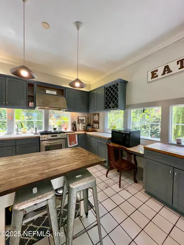 a kitchen with stainless steel appliances granite countertop table chairs sink and window