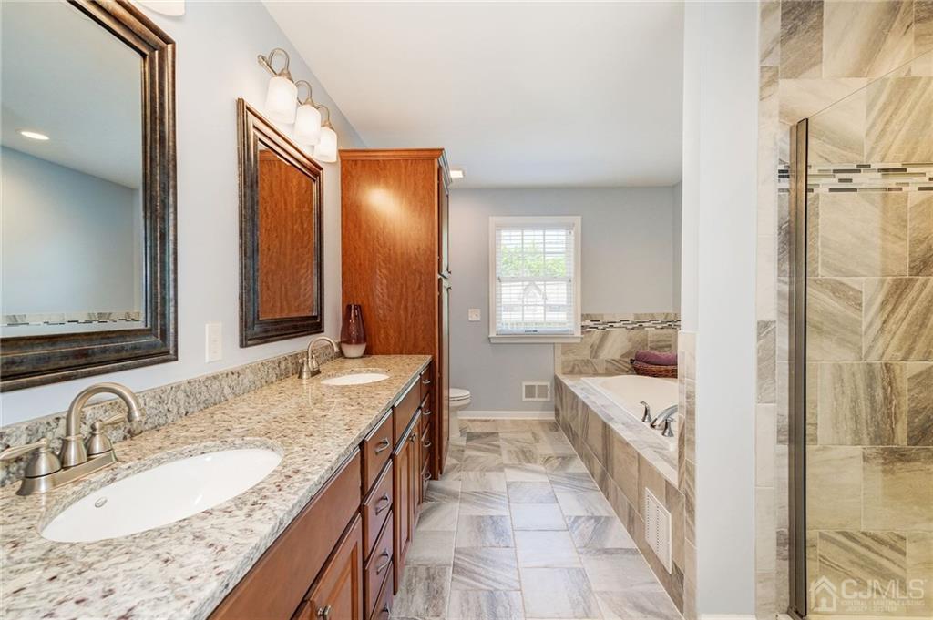 341 Dunellen Avenue Dunellen, NJ 08812 - Photo 15 of 24 a spacious bathroom with a granite countertop sink and a mirror