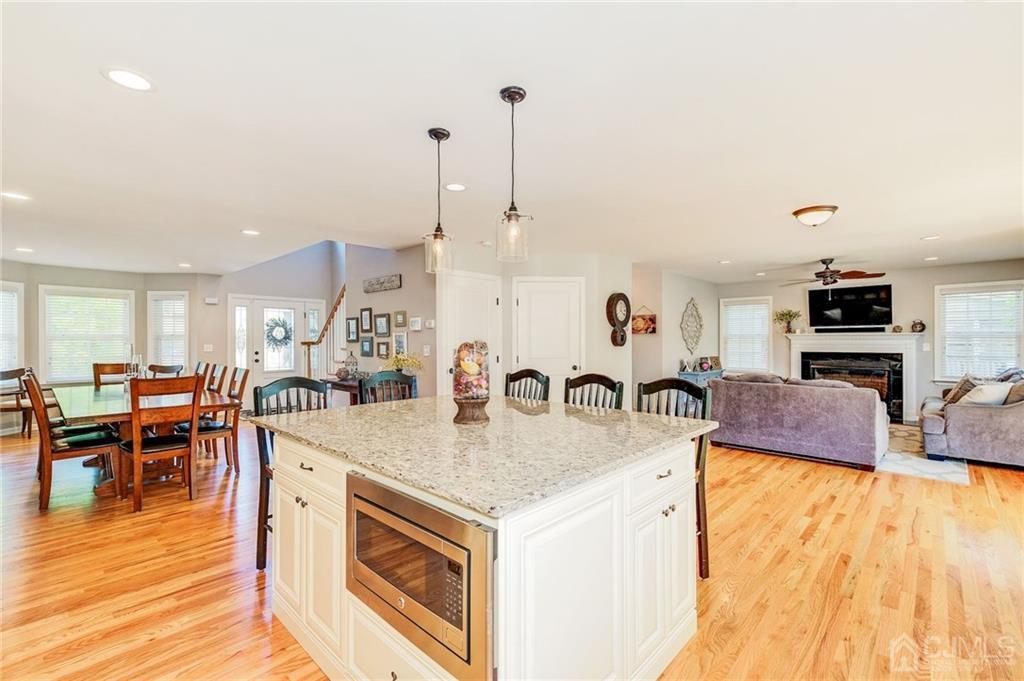 341 Dunellen Avenue Dunellen, NJ 08812 - Photo 8 of 24 a large kitchen with kitchen island a stove a sink a dining table and chairs with wooden floor