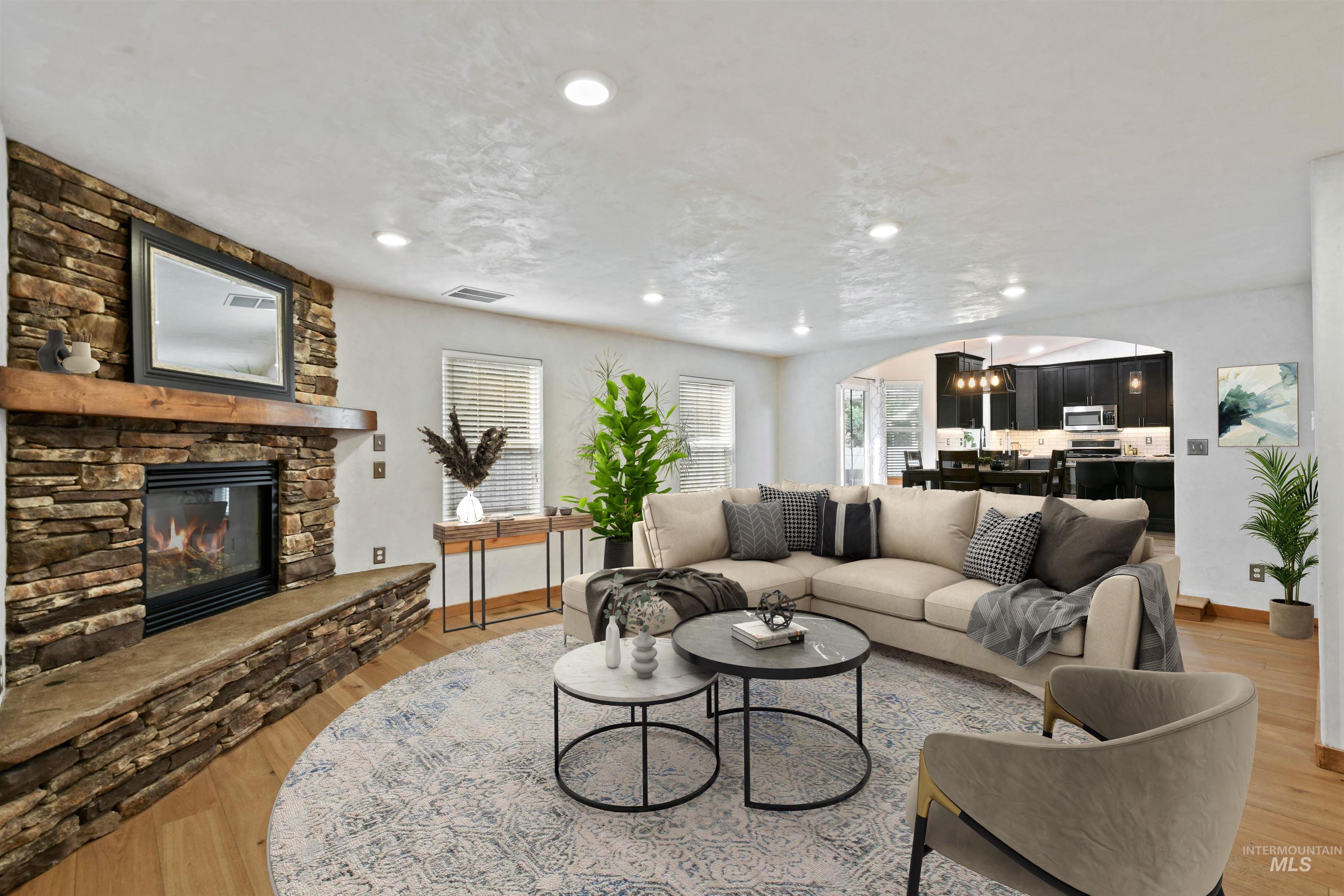 12019 West Rader Drive Boise, ID 83713 - Photo 5 of 41 Great room features arched entry with stone gas fireplace, hardwood floors, and recessed lighting.