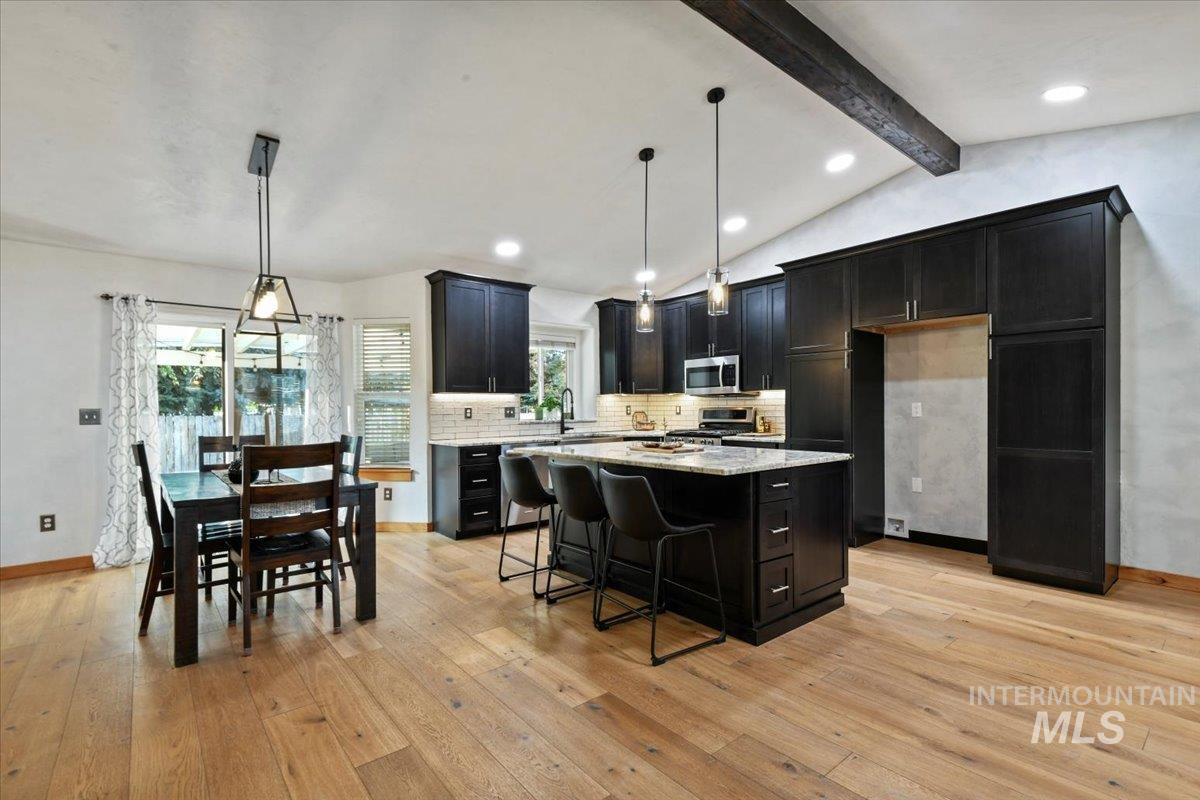 12019 West Rader Drive Boise, ID 83713 - Photo 10 of 41 Stunning remodeled kitchen with tasteful backsplash, a breakfast bar, decorative light fixtures, recessed lighting, and granite counters.