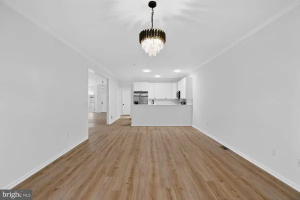 a view of a room with wooden floor and a chandelier