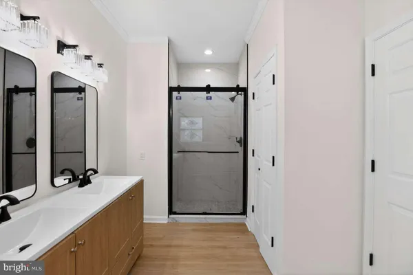 a bathroom with a double vanity sink a mirror and shower