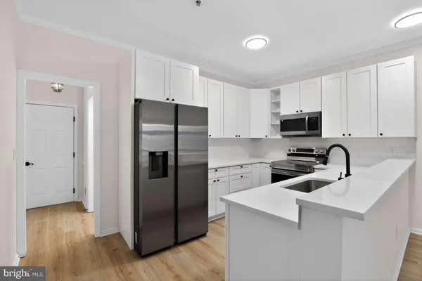 a kitchen with a refrigerator sink and cabinets