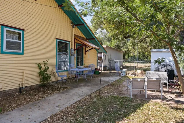 a view of a house with a yard and potted plants
