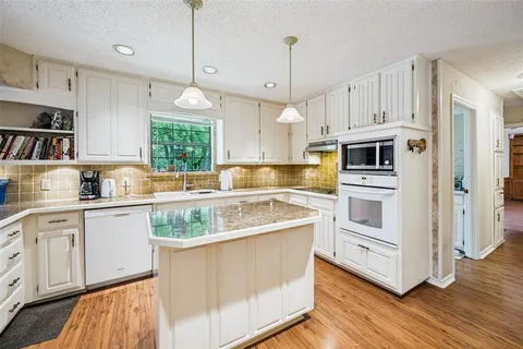 a kitchen with white cabinets and white appliances